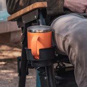 A stanley cup in a cup holder of a camp chair